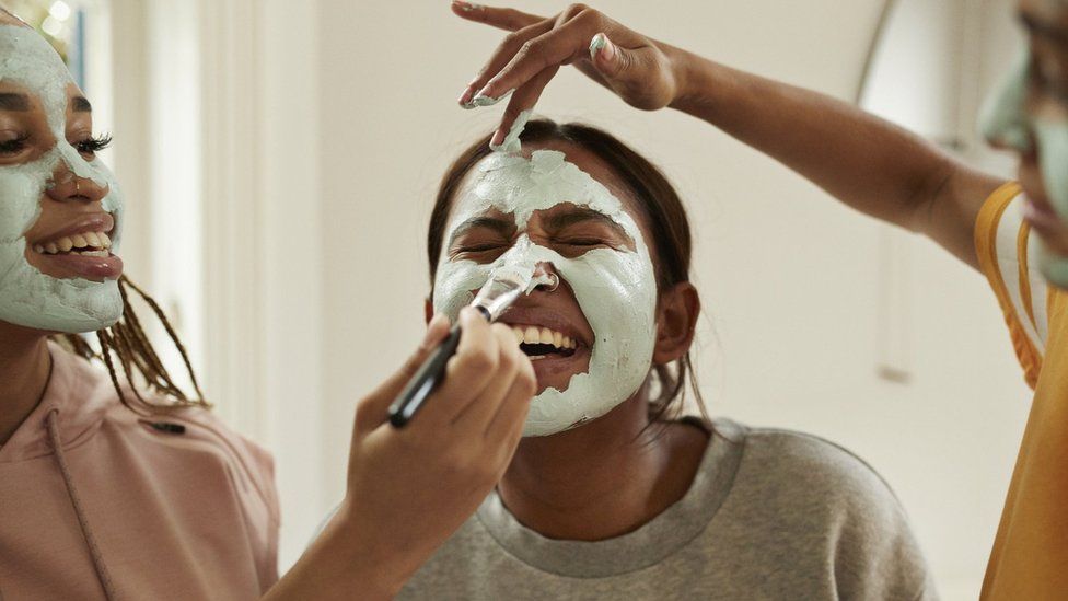Young women apply face masks