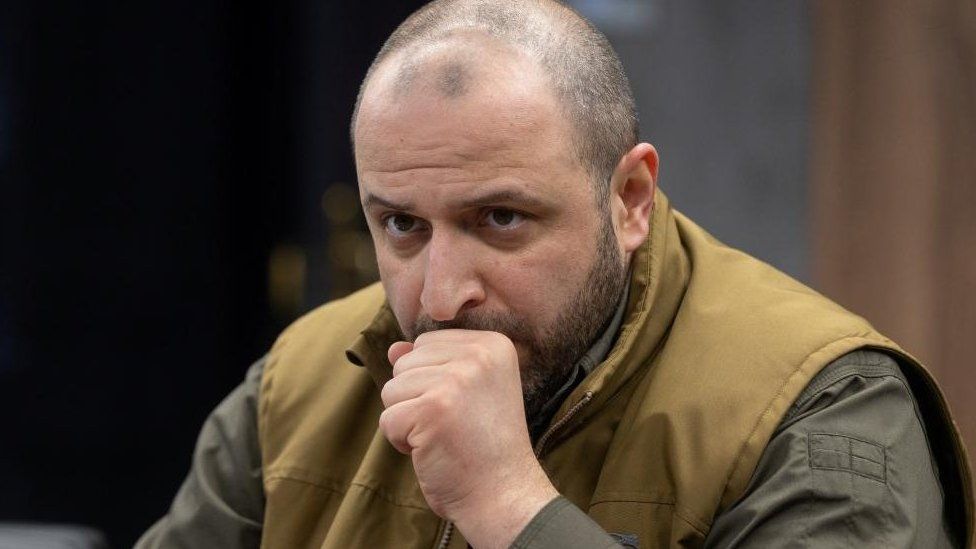 Ukraine's caput  of the State Property Fund sits with his fist adjacent  to his mouth