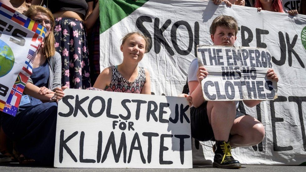 Greta Thunberg poses with other young climate activists at a rally