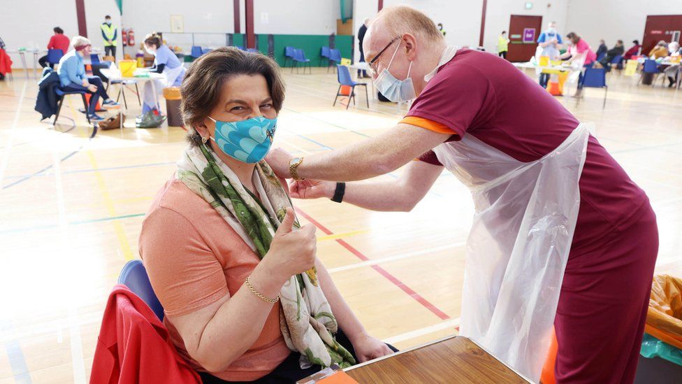 GP Dr John Porteous gives First Minister Arlene Foster her first Covid-19 vaccination at Castle Park Leisure Centre in Lisnaskea