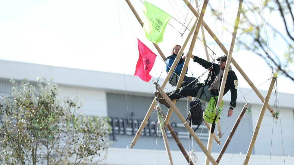 Protesters chained to bamboo structures outside the presses in Hertfordshire