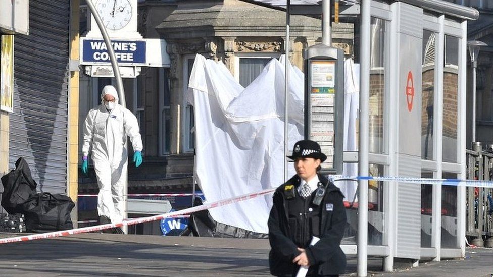 Police officer outside the scene of a stabbing at Ilford station