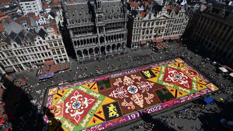 Eerial photograph shows the carpet of flowers from above surrounded by old belgian buildings