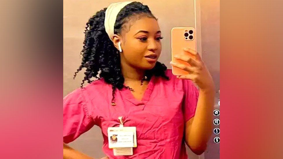 Owami Davies in pink nurses scrubs uniform
