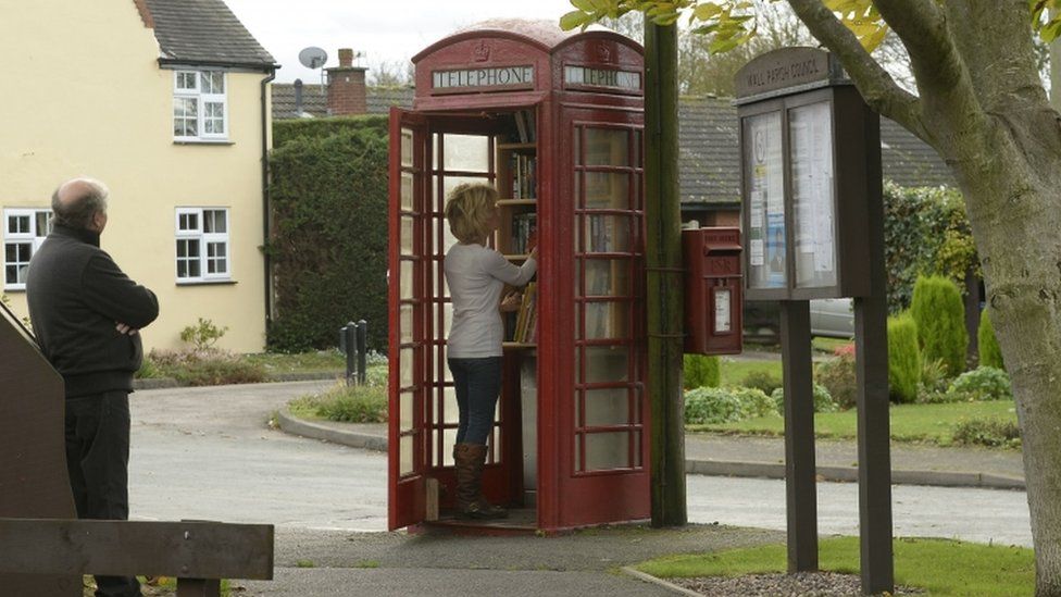 Wendy Hanlon looks at books in a red phone box
