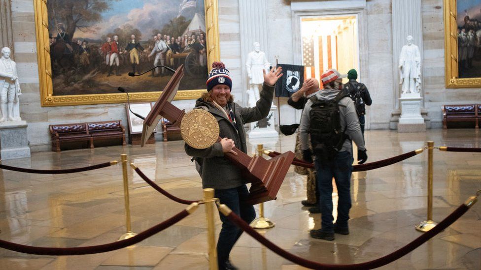 A man is pictured carrying the lectern from the House of Representatives