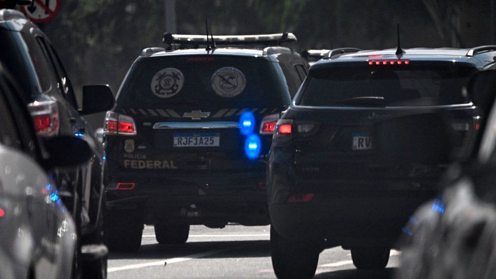 Federal Police vehicles drive on their way to the Federal Police headquarters after a raid on the house of councilman Carlos Bolsonaro in Rio de Janeiro, Brazil, on January 29, 2024.