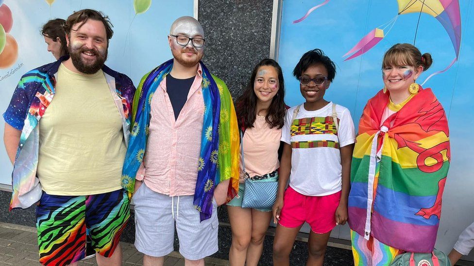 Five people wearing brightly coloured clothes