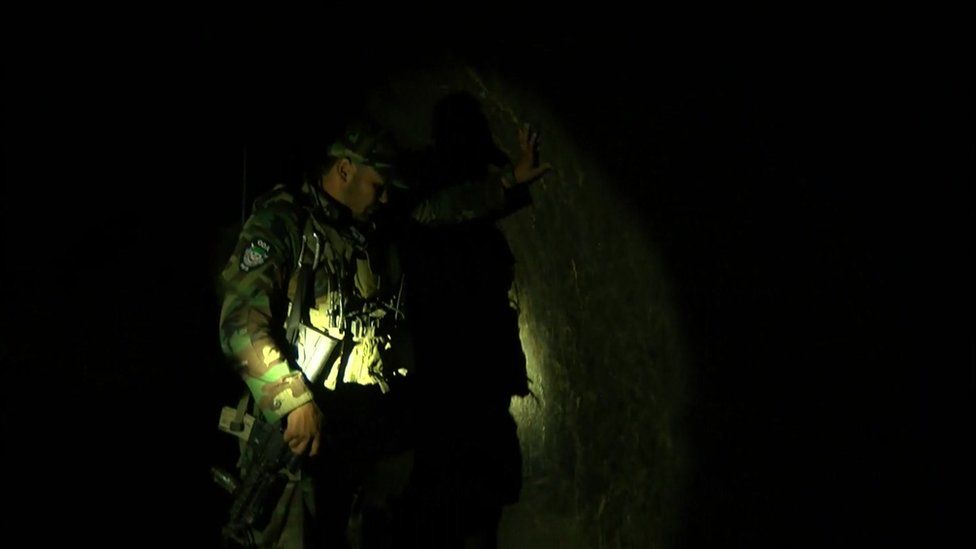 An Afghan special forces soldier shows the BBC round a cave inside the tunnel complex