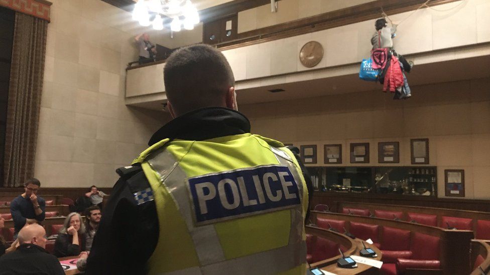 Cambridge City Council chamber and protesters and police