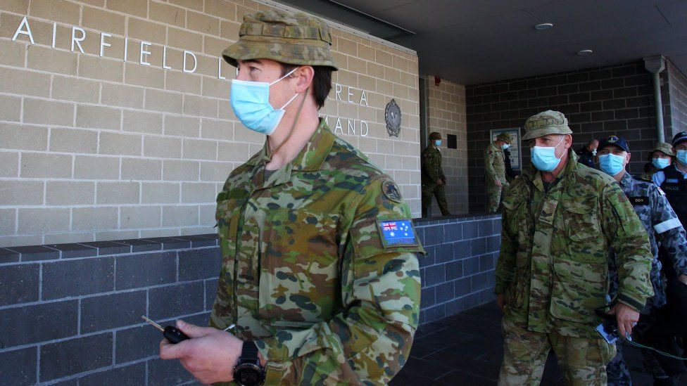 Defence personnel leave a police station in Fairfield, Sydney