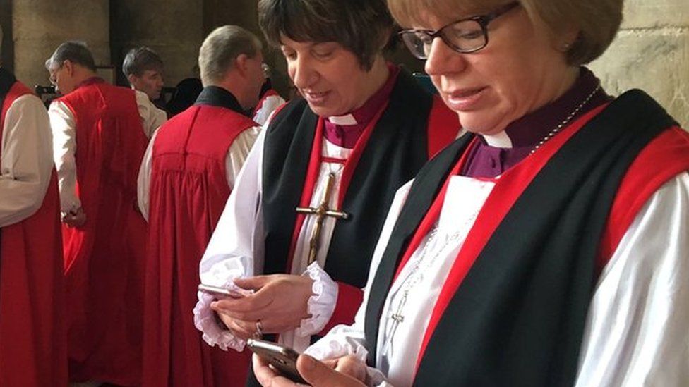 Bishop holding smartphones