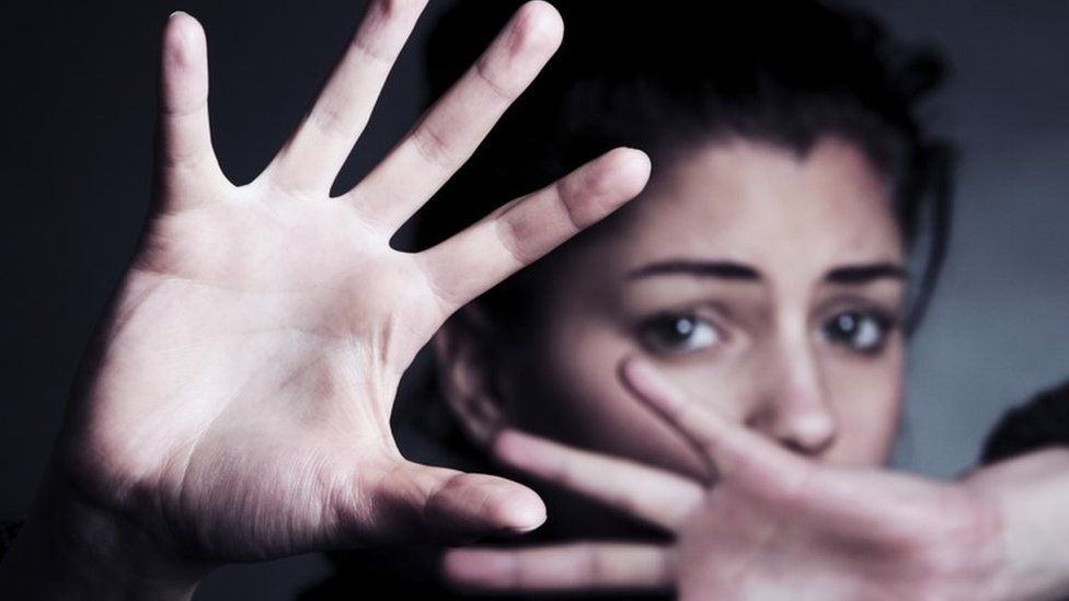 Woman shielding her face with her hands (posed by model)