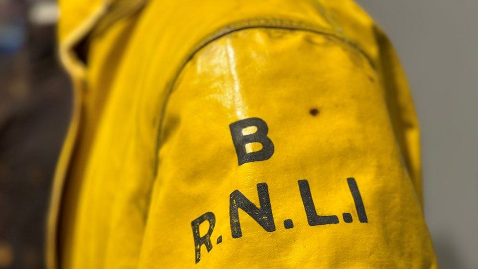 Close up of RNLI working on oilskins