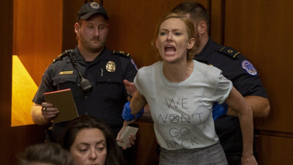 A protester is removed as Brett Kavanaugh appears before the Senate Judiciary Committee's confirmation hearing. 5 Sept 2018