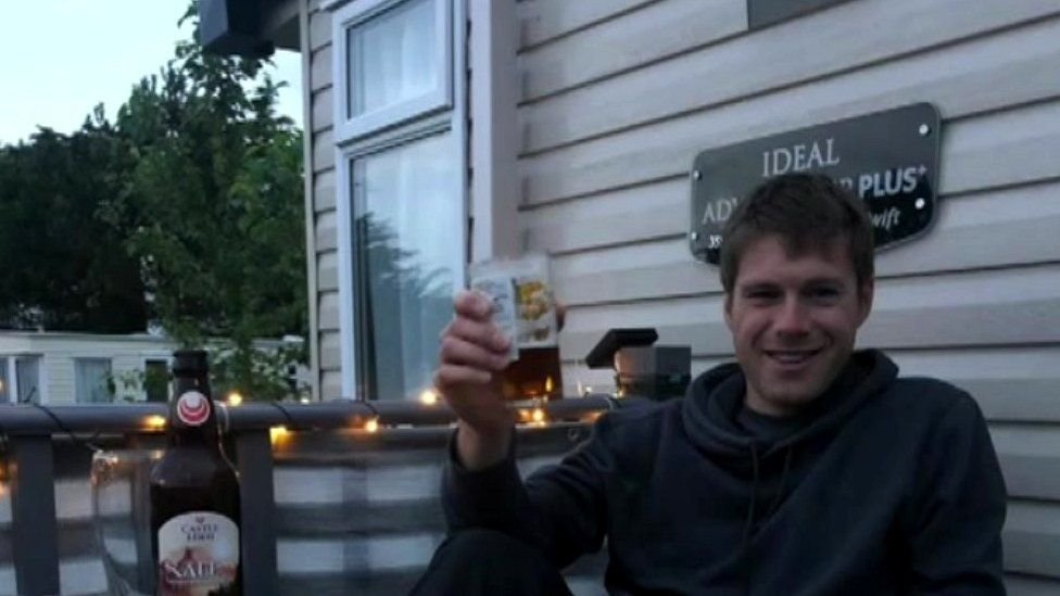 Chris with a beer outside his caravan