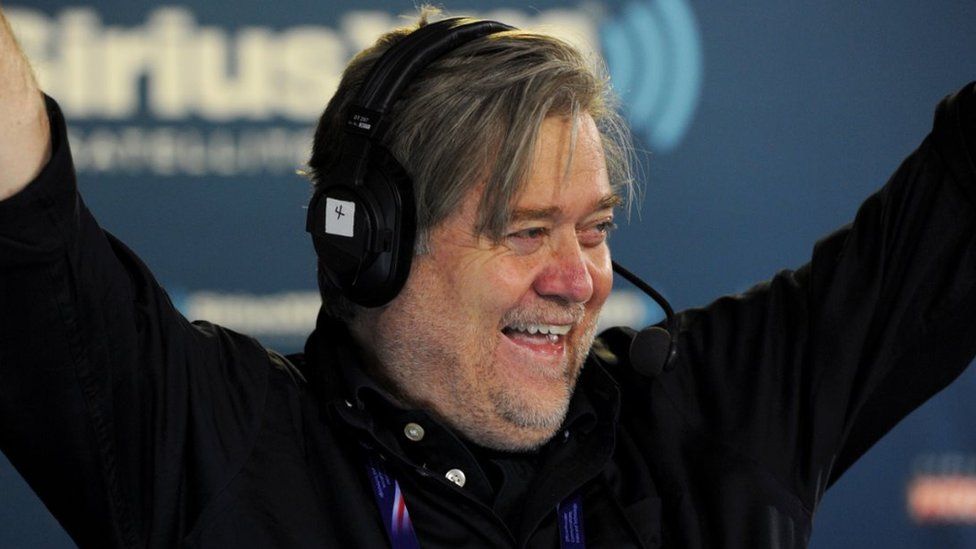 Stephen K Bannon raises his arms in the air during a radio show
