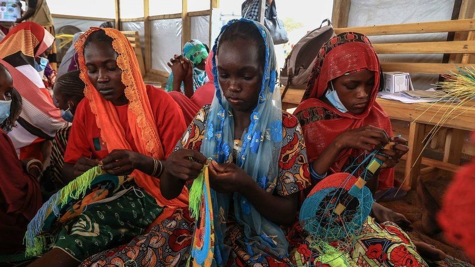 A group of women make fans in a workshop given by members of the NGO, Plan International, during a visit by Filippo Grandi, the United Nations High Commissioner for Refugees (UNHCR), in Maroua on April 28, 2022