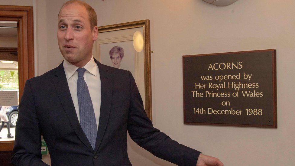 Prince William at Acorns Children's Hospice, next to a plaque commemorating his mother's visit 30 years ago