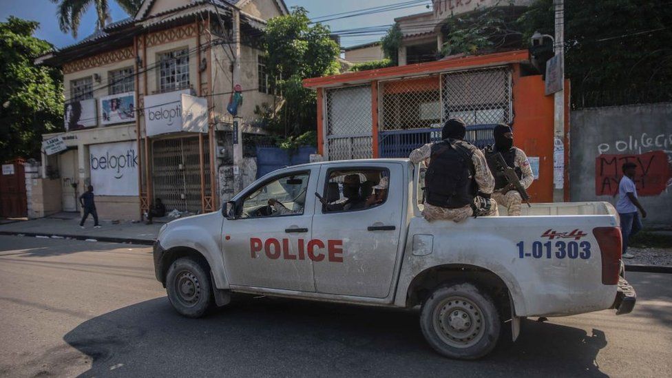 Armed police ride in the back of a truck in Port-au-Prince on 18 October