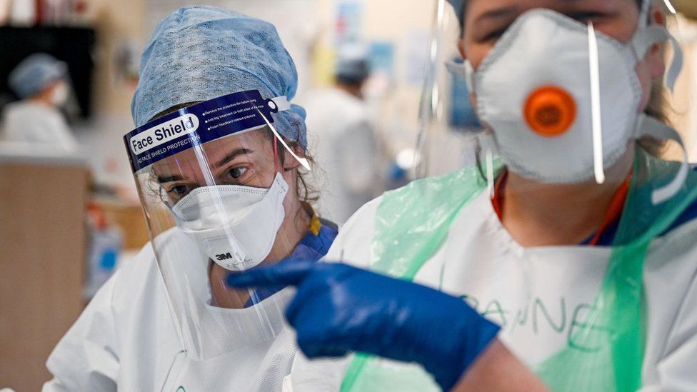 Médicos con mascarillas y escudos