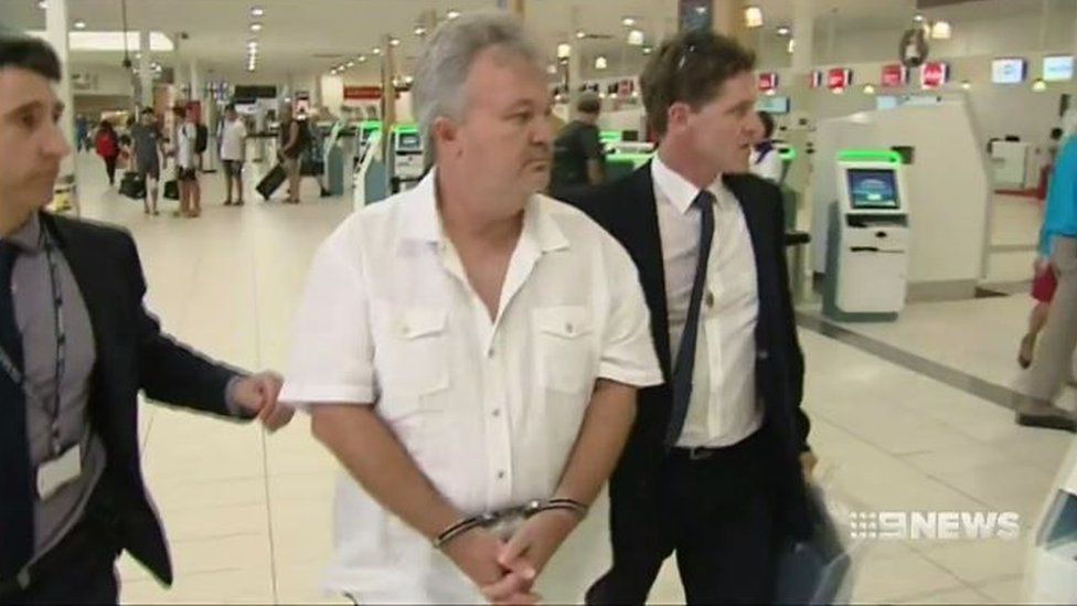 Фостера сопровождает полиция после ареста в Квинсленде