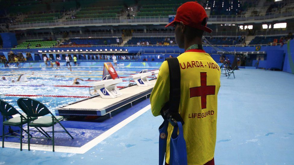 A lifeguard watches over swimmers in the Olympic pool