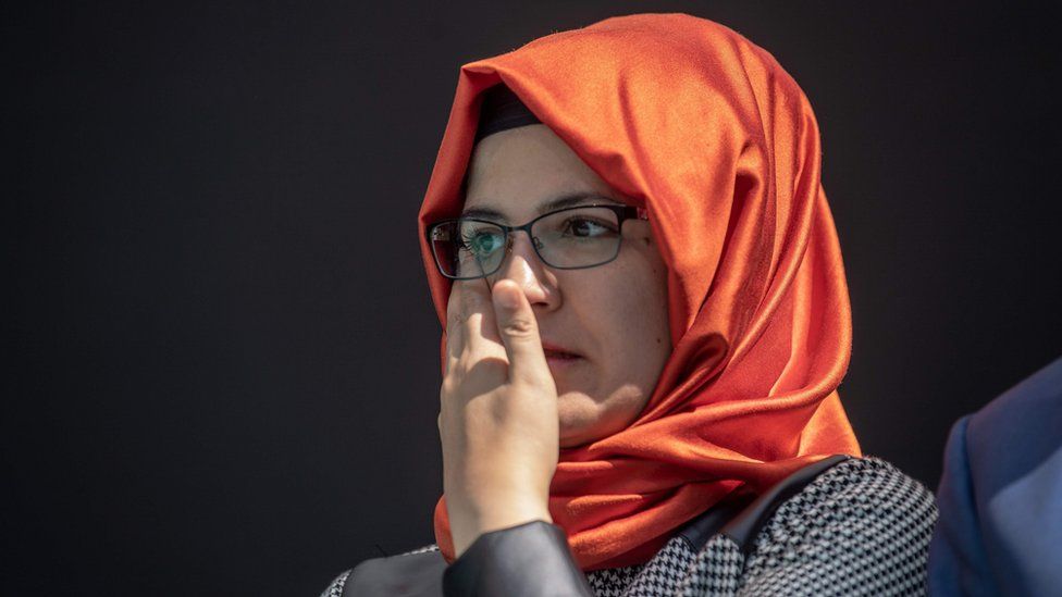 Hatice Cengiz, wearing an orange hijab and glasses, dries her eyes at a vigil for her late fiance Jamal Khashoggi, at the site of his murder in Istanbul