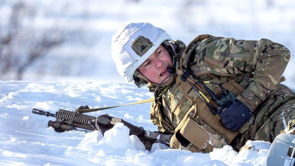 An image of a soldier lying down in the snow