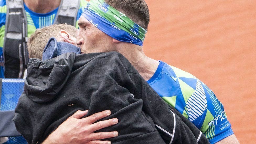 Kevin Sinfield carries Rob Burrow over marathon finishing line