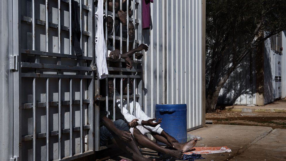 Migrants behind bars in a detention centre in Libya