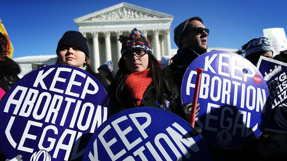 Pro-choice activists hold signs as marchers of the annual March for Life arrive in front of the US Supreme Court.