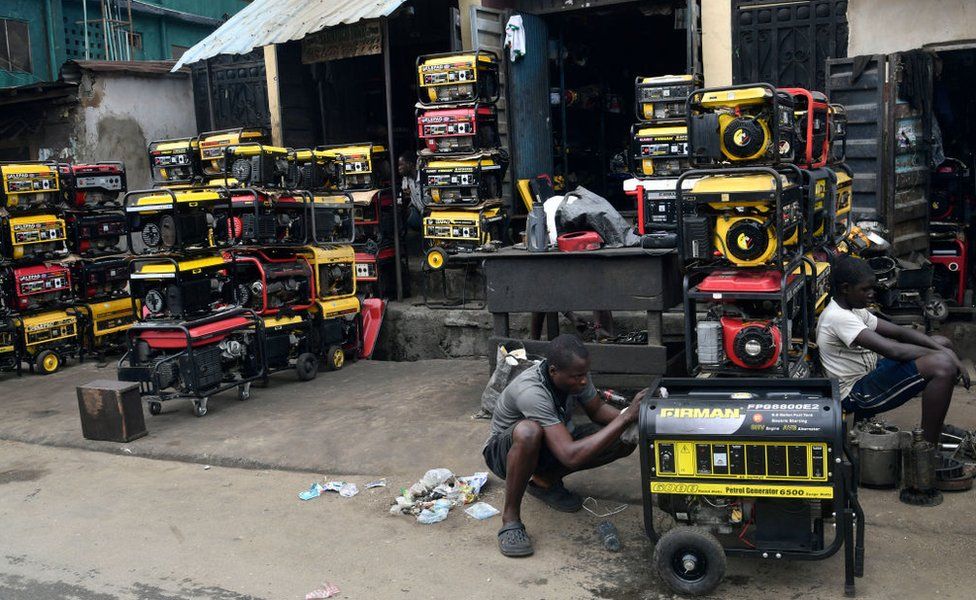 A man works in front of his shop selling yellow and red generators on 25 July 2023.