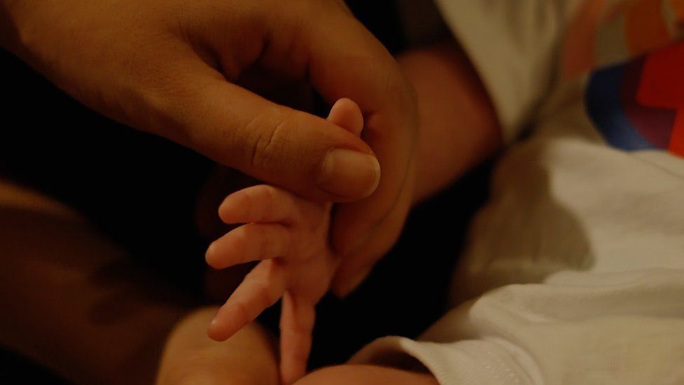 Close up on the hand of Aki and Hikari's baby