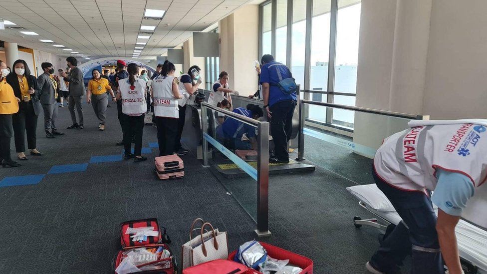 A medical team attends to the woman whose leg was trapped in a travelator