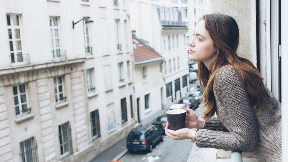 Young woman drinking coffee in a French flat