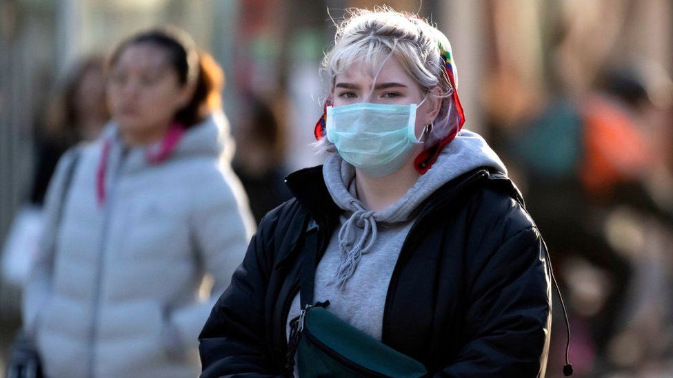A woman wearing a facemask in Cardiff city centre during coronavirus outbreak, 2020
