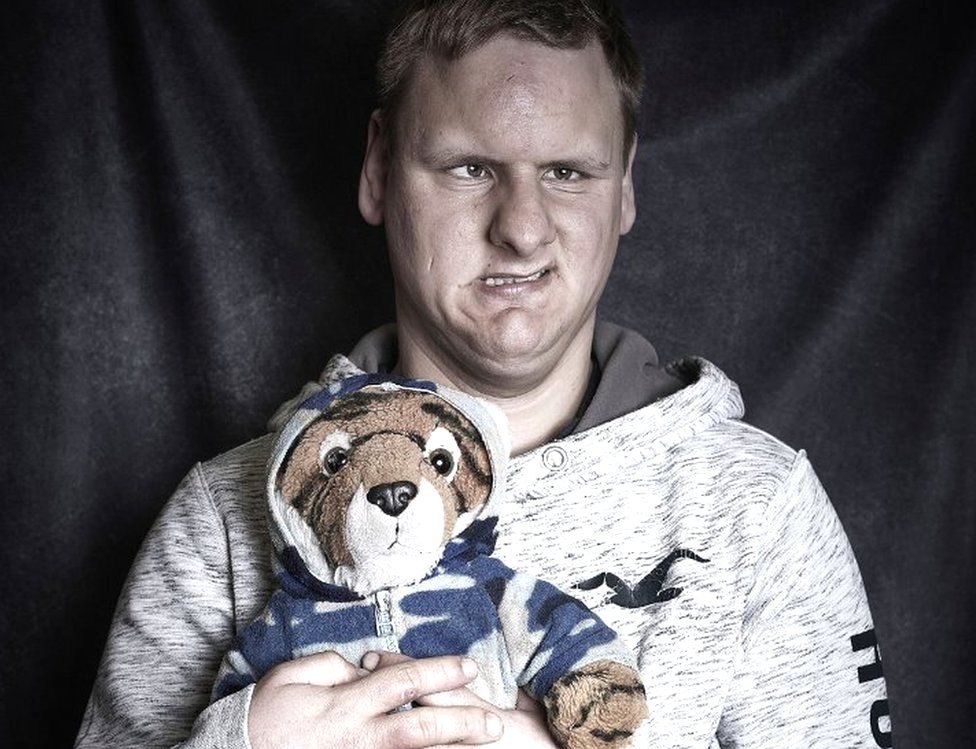 A man holds a tiger teddy bear