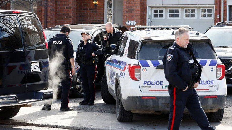 Ottawa Police Service officers surround a home after four children and two adults were found dead inside a neighbouring house in the Ottawa suburb of Barrhaven, Ontario, Canada