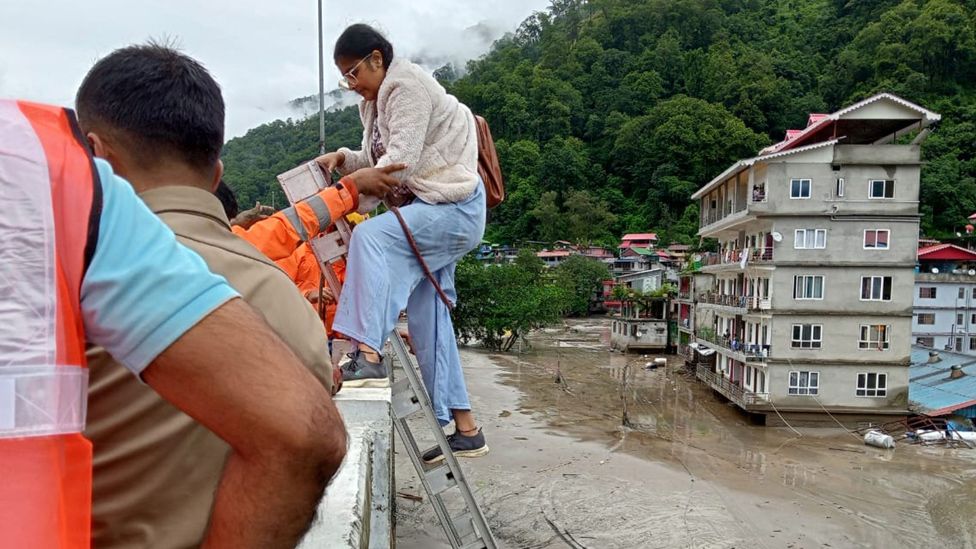 Woman being helped during a rescue operation in Sikkim