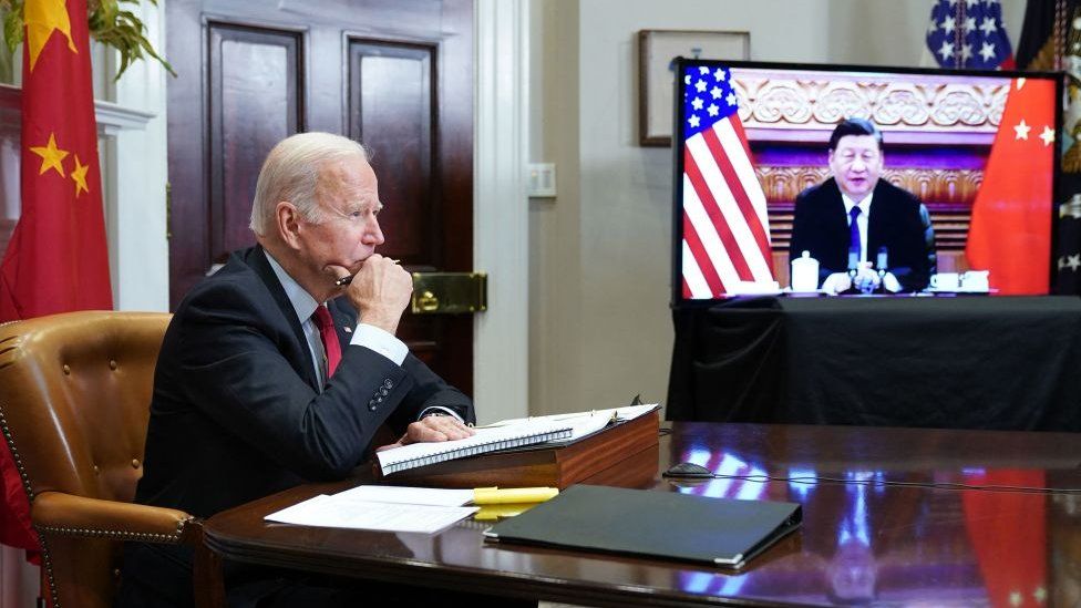 Biden sitting at table with Xi on a screen