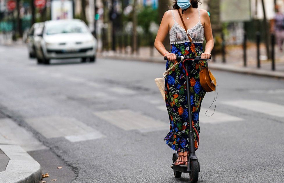 A woman rides an electric scooter in Paris, France, 20 August 2020