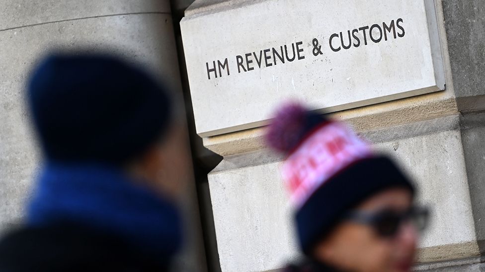 People walk by HM Revenue and Customs office