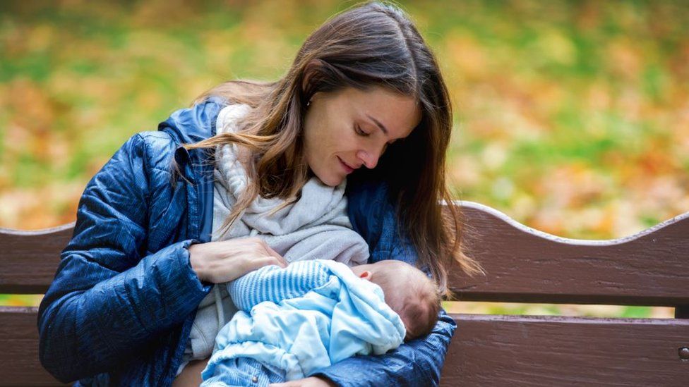 Woman breastfeeding in a park