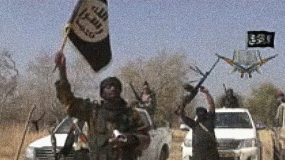 A screen grab made on January 20, 2015 from a video of Nigerian Islamist extremist group Boko Haram obtained by AFP shows the leader of the Islamist extremist group Boko Haram Abubakar Shekau holding up a flag as he delivers a message.