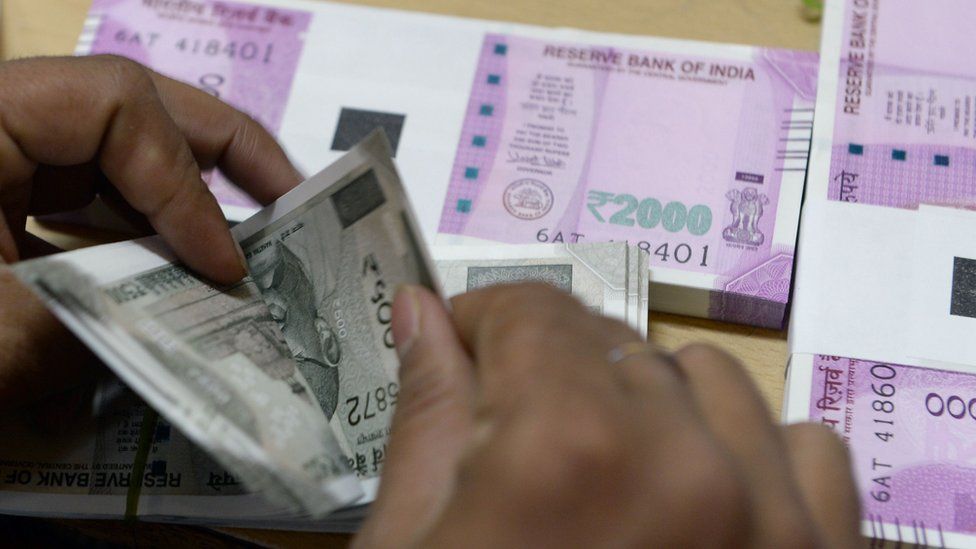 A man counts rupee notes