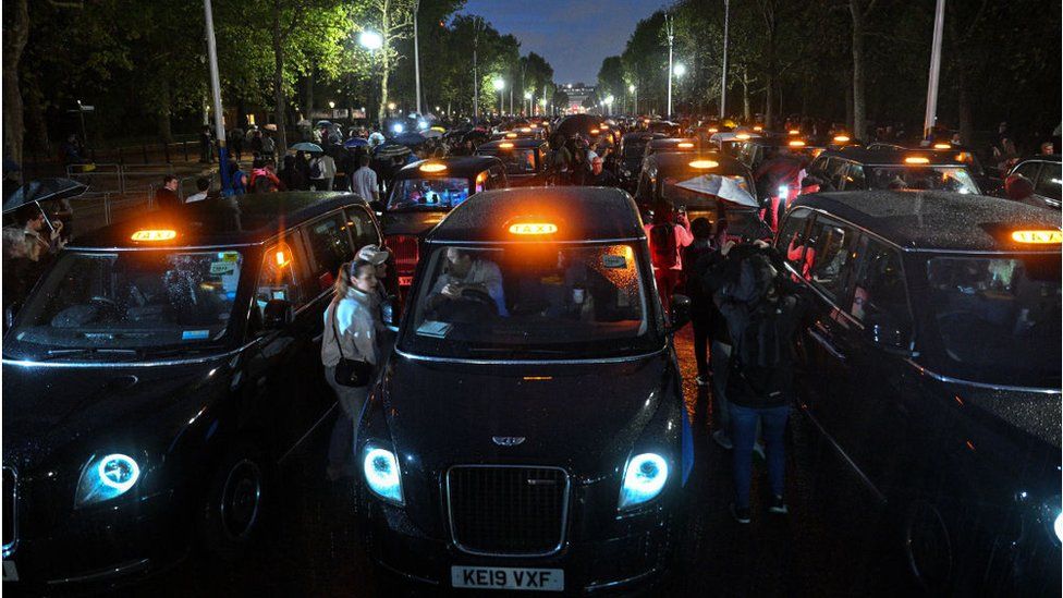 London black cabs lining The Mall leading up to Buckingham Palace to silently pay tribute to Queen Elizabeth II