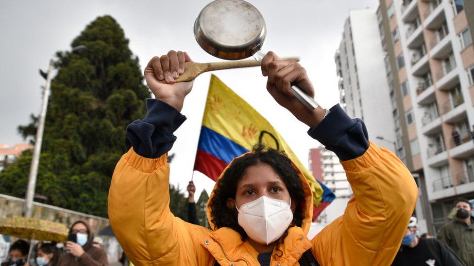 A demonstrator makes noise banging a pot during a protest against the government of President Ivan Duque on 4 May
