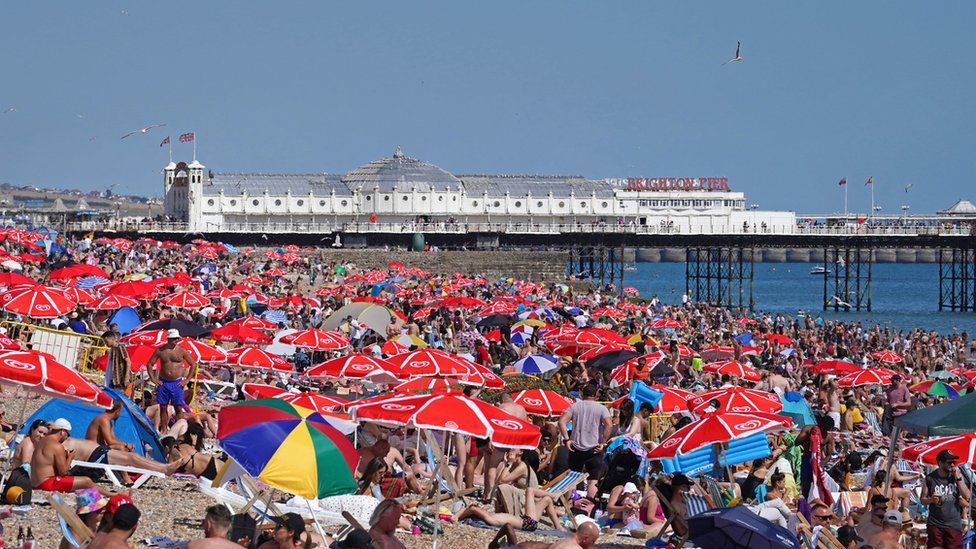People enjoy the warm weather at Brighton beach in West Sussex