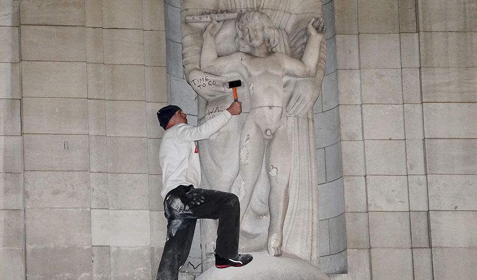 A man takes a hammer to a statue on the BBC's Broadcasting House in central London on Wednesday 12 January 2022